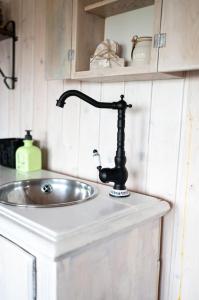 La salle de bains est pourvue d'un lavabo avec un robinet noir sur un comptoir. dans l'établissement Naphegy Kuckó, à Écs