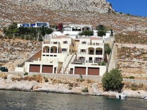a large house on a hill next to the water at Aktea coastal village home in Kalymnos