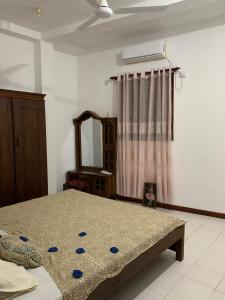 1 dormitorio con cama y espejo en Little Apartment, en Galle