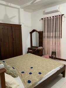 1 dormitorio con cama y espejo en Little Apartment, en Galle