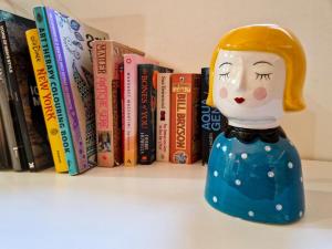 a figurine on a shelf in front of books at Casa Acquario Centro MaMaisonGenova in Genoa