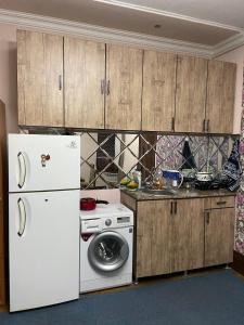 a kitchen with a white refrigerator and a washing machine at Hostel Highway in Samarkand