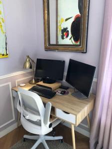 a desk with two computer monitors and a white chair at Gobelins in Paris