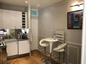 a kitchen with a sink and a table with stools at Gobelins in Paris