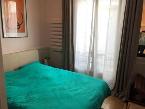 a bedroom with a green bed in front of a window at Gobelins in Paris