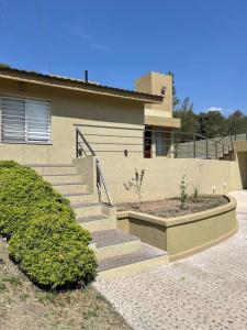 a house with stairs in front of a house at Chalet al pie del camino al cuadrado in Río Ceballos