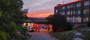 a building with a car parked in a parking lot at Travelodge by Wyndham Baie Comeau in Baie-Comeau