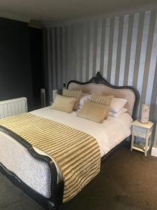 a bedroom with a large bed with two pillows at The Vine Hotel, Skegness in Skegness