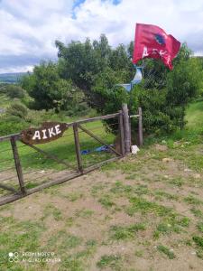 una valla con bandera y una puerta con bandera en Aike Cabañas de Montaña en San Clemente