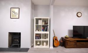 un soggiorno con mensola bianca e chitarra di Bath City Skyline Spacious 3 Bed House for family a Bath