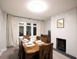 a dining room with a table and chairs and a fireplace at Bath City Skyline Spacious 3 Bed House for family in Bath
