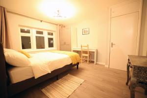 una camera con letto, scrivania e finestra di Bath City Skyline Spacious 3 Bed House for family a Bath