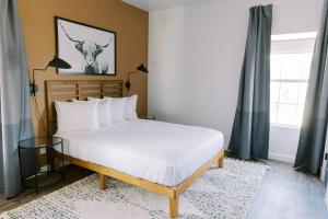 a bedroom with a bed with white pillows at Unit 222 - The Lyndon 1 Bed - Cation on the Guadalupe in New Braunfels