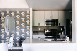 a kitchen with a stove and a microwave at Unit 222 - The Lyndon 1 Bed - Cation on the Guadalupe in New Braunfels