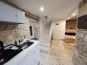 eine Küche mit einem Waschbecken und einer Treppe in der Unterkunft La P'tite Écurie in Saint-Jean-de-Liversay