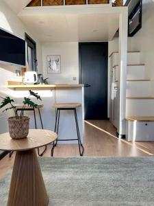a room with a kitchen with a table and a counter at Tiny house with sauna & jacuzzi near Amsterdam in Vijfhuizen