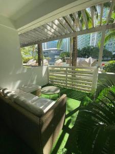 einen Balkon mit einem Sofa, einem Tisch und Stühlen in der Unterkunft Azure BEACHfront view Aesthetic Minimalist unit in Manila