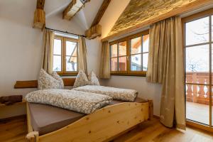 a bedroom with a bed in a room with windows at Goiserer Chalet in Bad Goisern