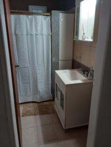 ein Badezimmer mit einem weißen Duschvorhang und einem Waschbecken in der Unterkunft departamento el atardecer in Chascomús