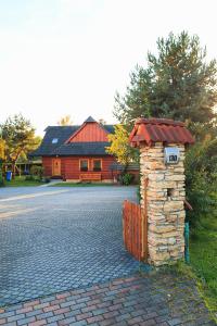 a house with a stone pillar with a roof at River Cottage Bešeňová in Bešeňová