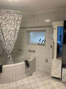 ein Bad mit einer Badewanne und einem Fenster in der Unterkunft Maison Grande Fleur in Metterich