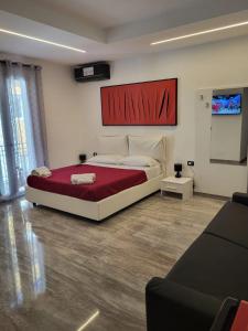 a bedroom with a large bed with a red blanket at Dimore Pietrapenta Apartments, Suites & Rooms - Via Lucana 223, Via Piave 23, Via Chiancalata 16 in Matera