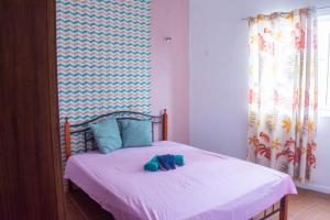 ein Schlafzimmer mit einem Bett mit zwei blauen Schuhen darauf in der Unterkunft Montaguvilla#3 in Flic-en-Flac + 5 Fotos