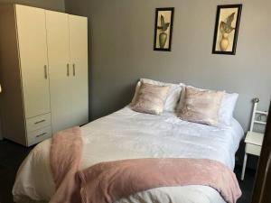 ein Schlafzimmer mit einem großen weißen Bett mit Kissen in der Unterkunft Mels Place in Bloemfontein