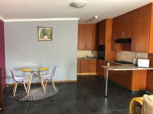 eine Küche mit einem Tisch, Stühlen und einer Theke in der Unterkunft Mels Place in Bloemfontein