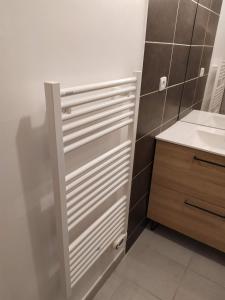 um armário branco numa casa de banho com um lavatório em Petit chemin des Flouries em Gaillac