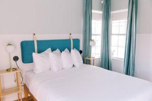 a bedroom with a large white bed with blue curtains at Unit 213 - The Strand 2 Bed - Cation on the Guadalupe in New Braunfels