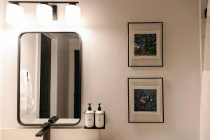 a bathroom with a mirror and pictures on the wall at Unit 211 - The Lyndon 1 Bed - Cation on the Guadalupe in New Braunfels