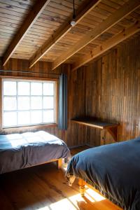 a bedroom with two beds and a window at Encantadora Cabaña del Lago - Parque La Pirámide in La Florida