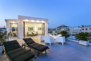 a patio with couches and tables on a balcony at Acropolis Panorama View Penthouse with Private Terraces A Contemporary Parthenon in Athens