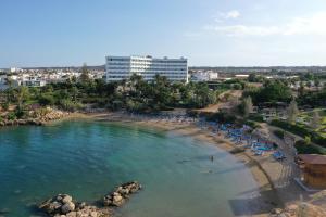 una playa con sombrillas y sillas en el agua en The Blue Fish Apartment, en Protaras