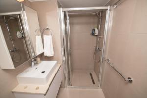 un baño con ducha y lavabo en The Blue Fish Apartment, en Protaras 26 fotos más