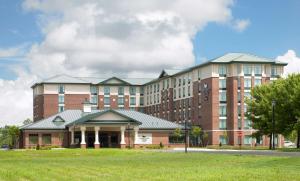 a large red brick building with a green field at Homewood Suites by Hilton Hartford South-Glastonbury in Glastonbury