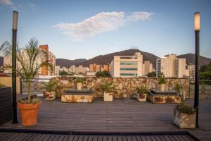 einen Balkon mit Topfpflanzen und einer Skyline der Stadt in der Unterkunft Hotel Inkai in Salta
