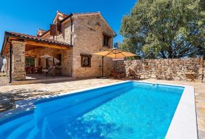 una piscina di fronte a una casa in pietra di MY DALMATIA - Authentic villa Malou with private swimming pool a Stankovci