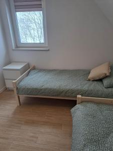 a bedroom with two beds and a window at Słoneczna Sielanka domki w Bieszczadach in Ustrzyki Dolne