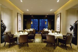 um restaurante com mesas e cadeiras num quarto em DoubleTree by Hilton Beijing em Pequim