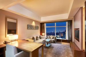 een woonkamer met een bank en een groot raam bij DoubleTree by Hilton Beijing in Beijing