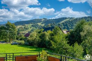 a view of a green field with trees and mountains at Agroturystyka Corno Owca in Żabnica