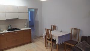 Apartament Szczęśliwicka في وارسو: مطبخ مع طاولة وكراسي ومطبخ مع موقد