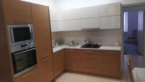 a kitchen with wooden cabinets and a sink and a microwave at Apartament Szczęśliwicka in Warsaw +4 photos