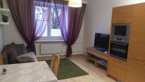 a living room with a tv and a window at Apartament Szczęśliwicka in Warsaw