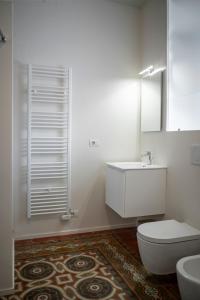 uma casa de banho com um WC, um lavatório e um espelho. em Piazza Mascheroni Home em Bérgamo