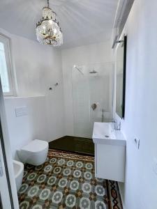 uma casa de banho com um lavatório, um WC e um lustre em Piazza Mascheroni Home em Bérgamo