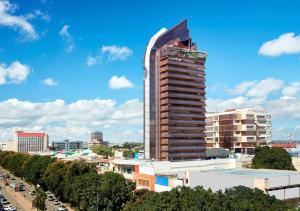 ein großer Wolkenkratzer in einer Stadt mit Autos in der Unterkunft Hilton Garden Inn Society Business Park in Lusaka