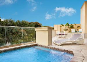 a swimming pool on a patio with chairs and a table at Hilton Garden Inn Society Business Park in Lusaka